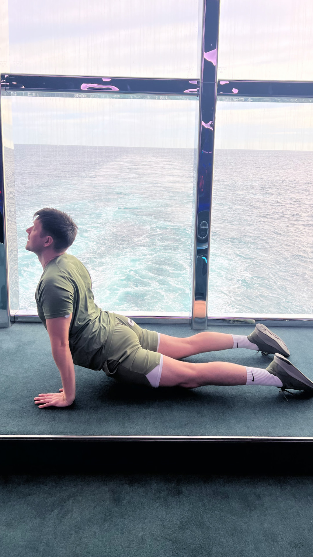 Jason in a Pilates cobra stretch in front of floor-to-ceiling ocean windows