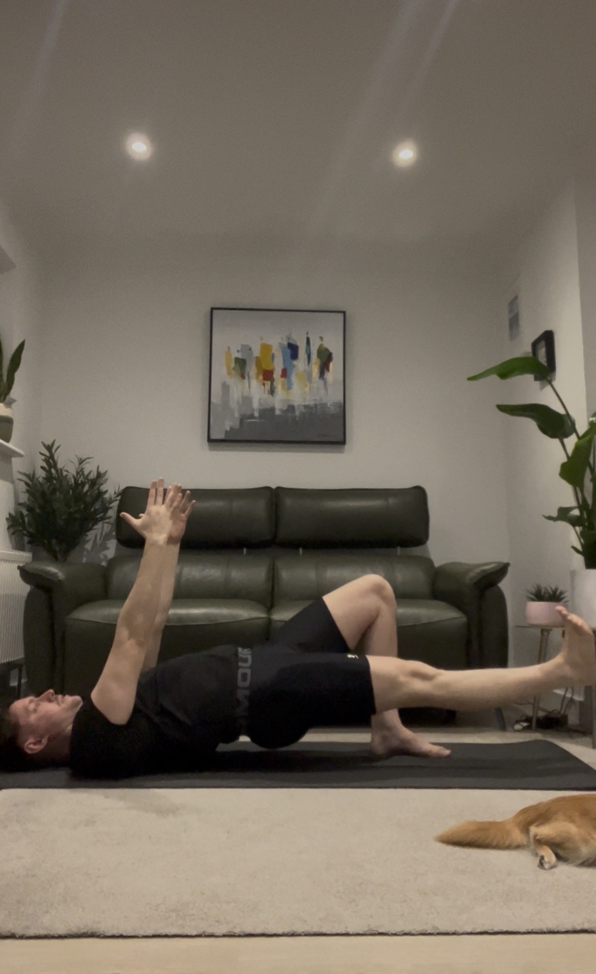 Jason performing a Pilates shoulder bridge with one leg extended