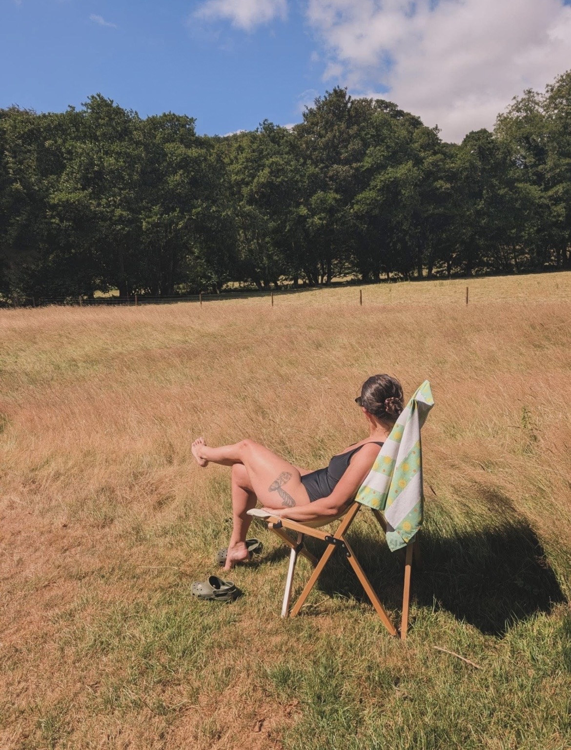 Guest relaxing in a deckchair in a sunlit Cornish meadow