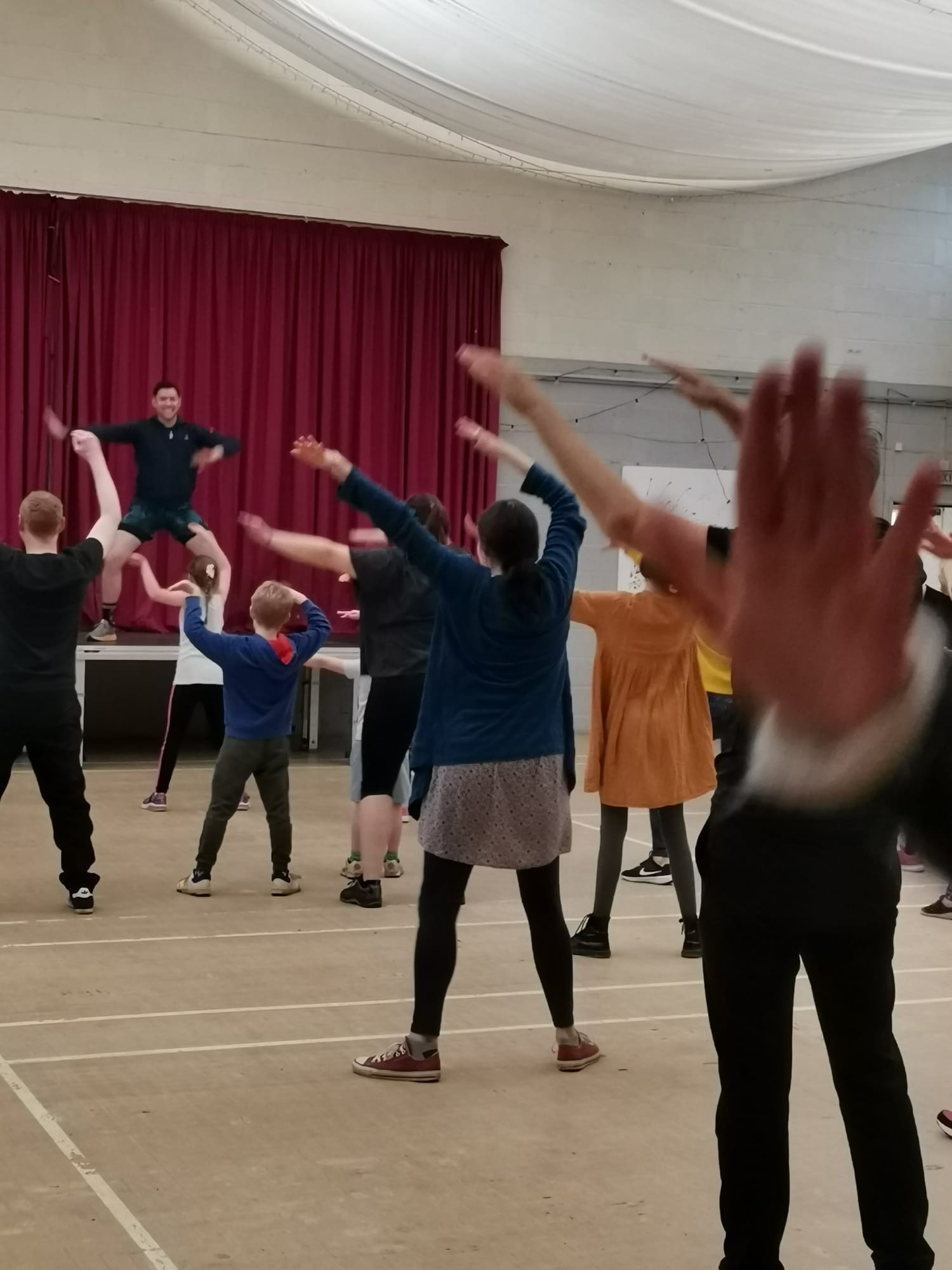 Class members with arms raised during a Zumba class