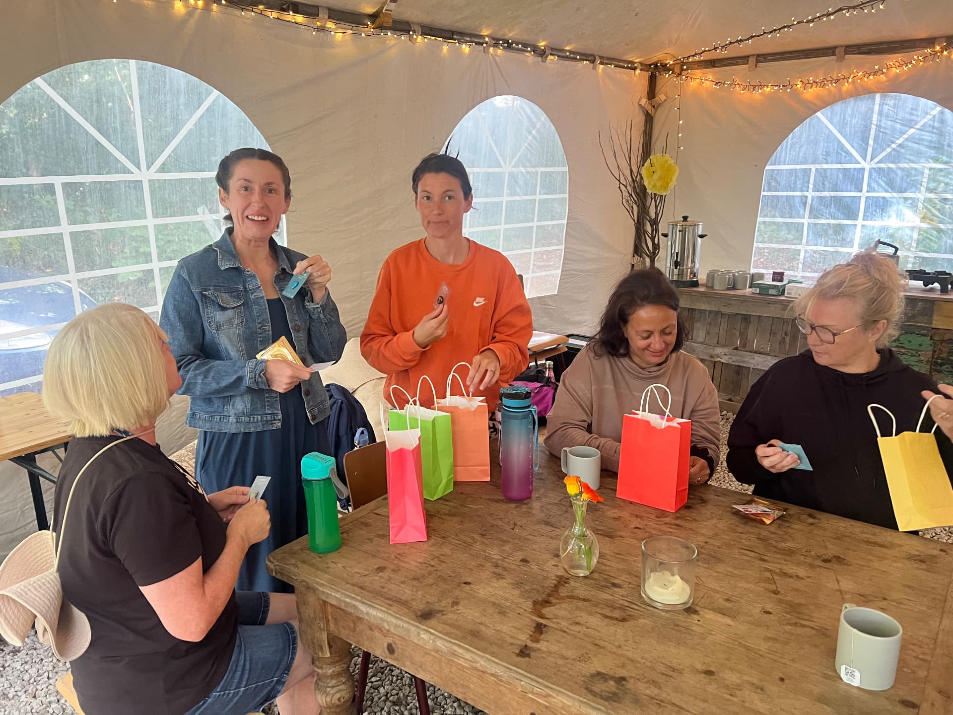 Retreat guests opening gift bags around the table in the marquee