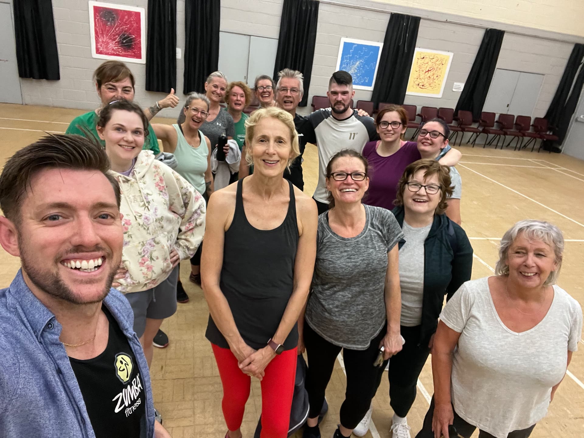Jason in his Zumba tee taking a group selfie with his class
