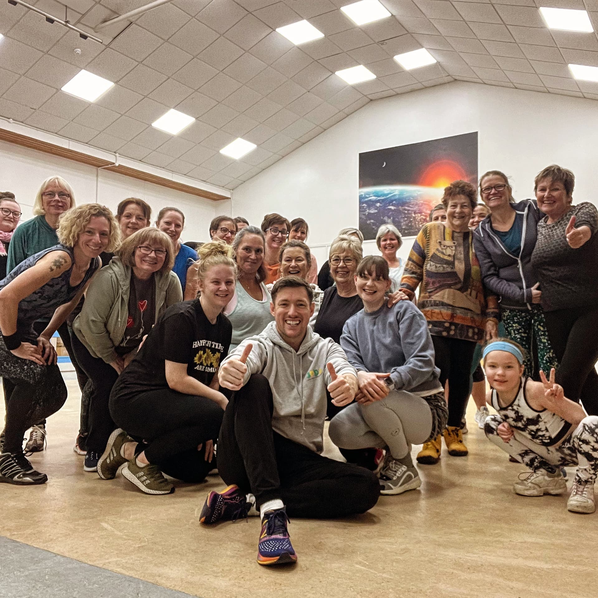 Jason and a large class giving thumbs up after a Zumba session