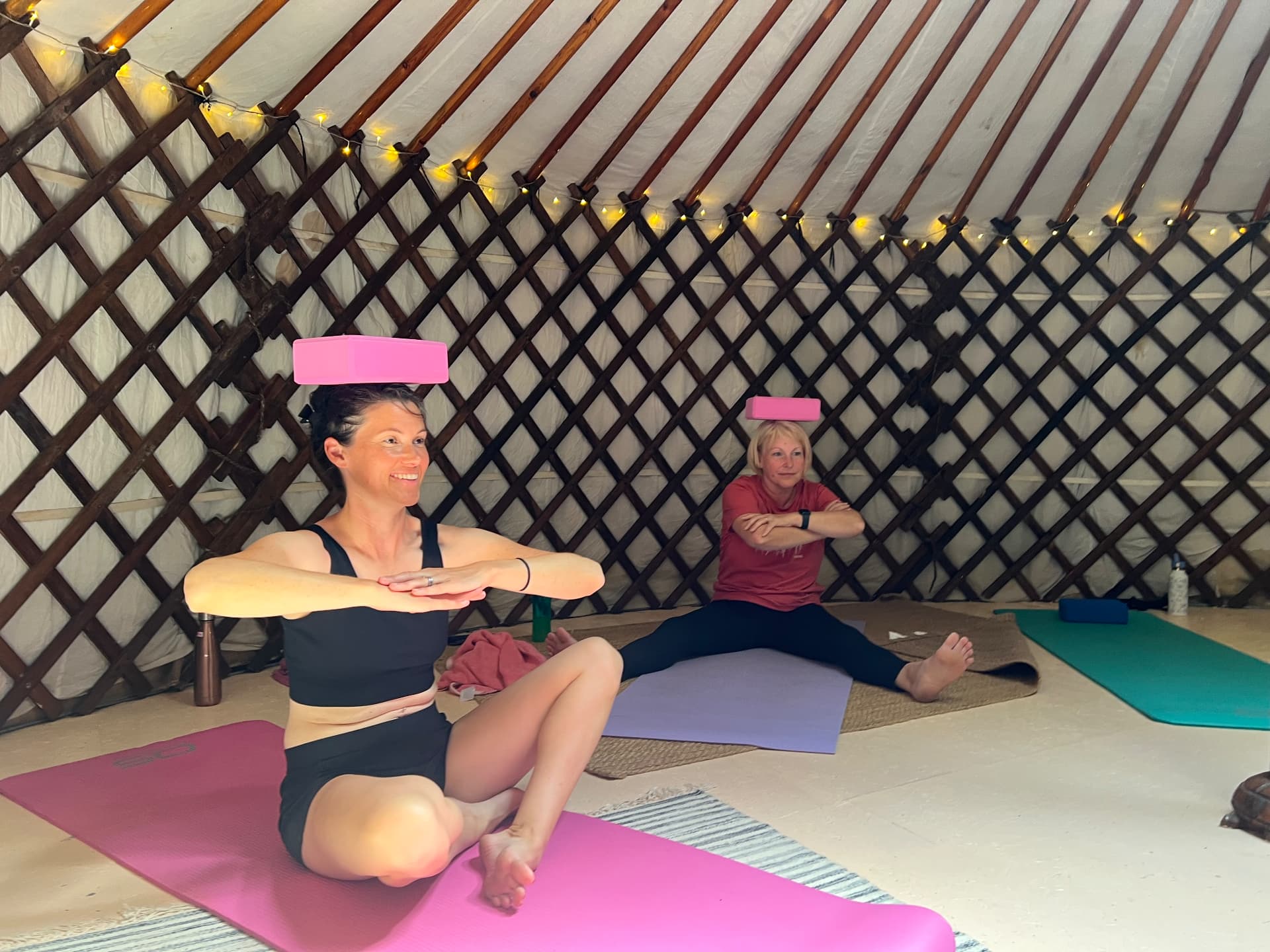 Retreat guests balancing yoga blocks on their heads during a Pilates session