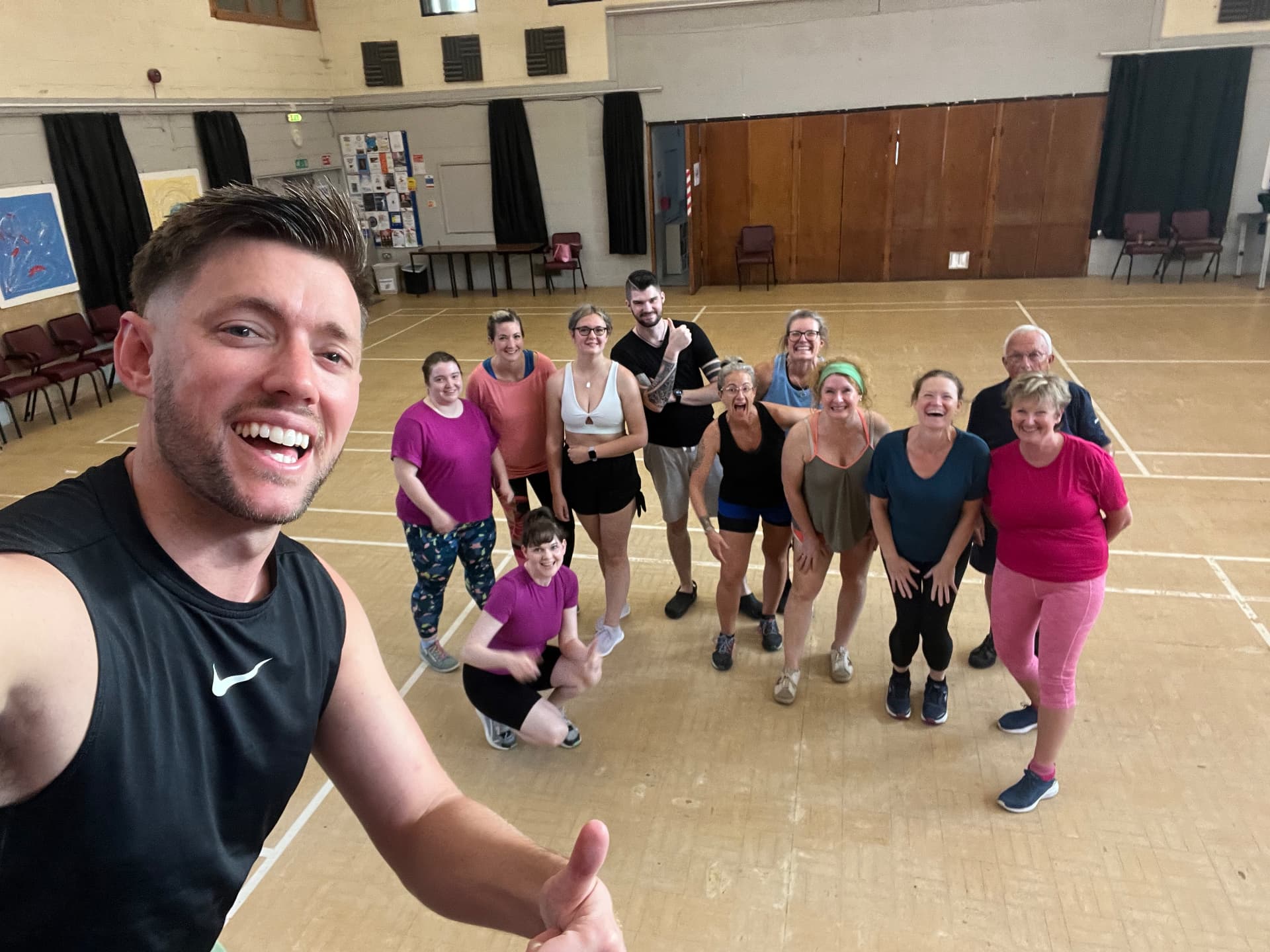 Jason taking a selfie with his smiling class in a village hall