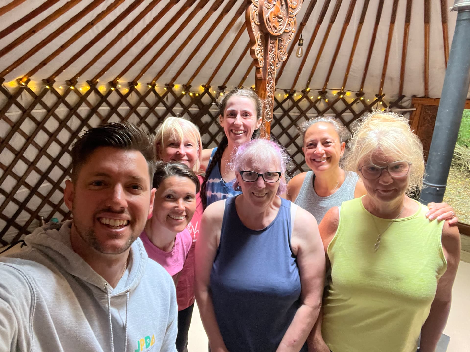 Group selfie with Jason and retreat guests inside the yurt